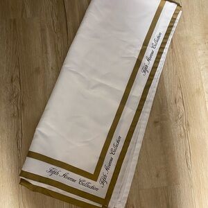 Fifth Avenue Collection White and Gold Tablecloth with Script Border 148” x 66”